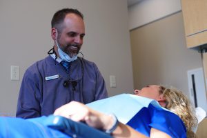 Male Dentist Smiling Down at Female Patient