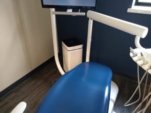 Blue Dental Chair Next to Rack of Instruments