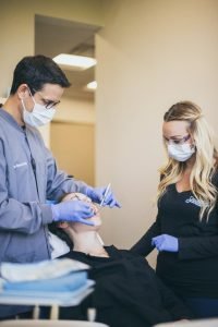 Dentist Performing Procedure With Assistant